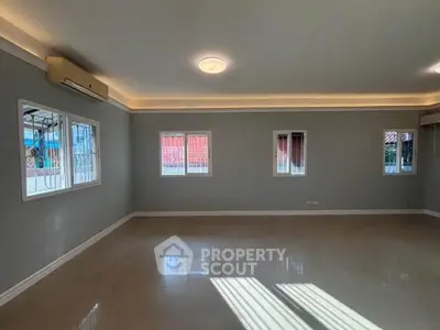 Spacious empty living room with large windows and tiled floor