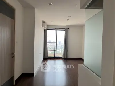 Spacious apartment interior with large window and city view, perfect for modern living.