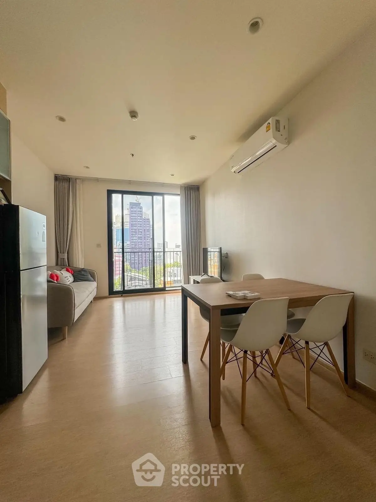 Modern living room with balcony view and stylish furniture in a high-rise apartment.