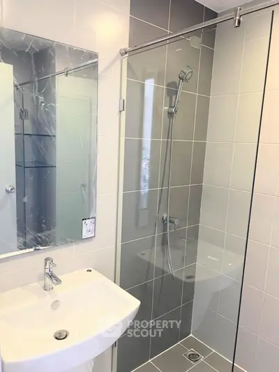 Modern bathroom with sleek shower and stylish sink in contemporary design.