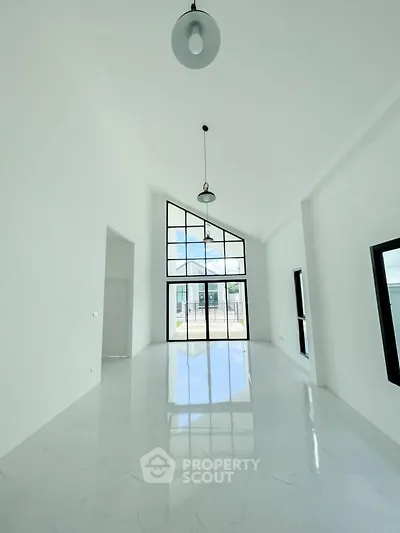 Spacious modern living room with high ceilings and large windows offering abundant natural light.