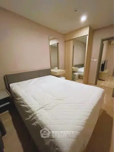 Cozy bedroom with modern design and ample storage space in a stylish apartment.