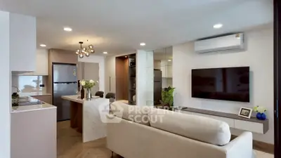 Modern living room with open kitchen, stylish decor, and sleek appliances in a cozy apartment.