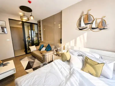 Modern bedroom with stylish decor and cozy seating area in a luxurious apartment.