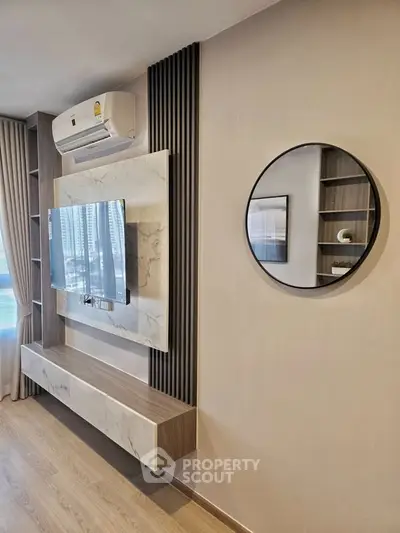 Modern living room with sleek TV setup and stylish decor in a contemporary apartment.