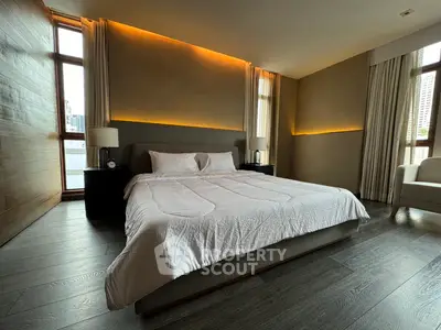 Luxurious bedroom with modern design and ambient lighting, featuring large windows and elegant decor.
