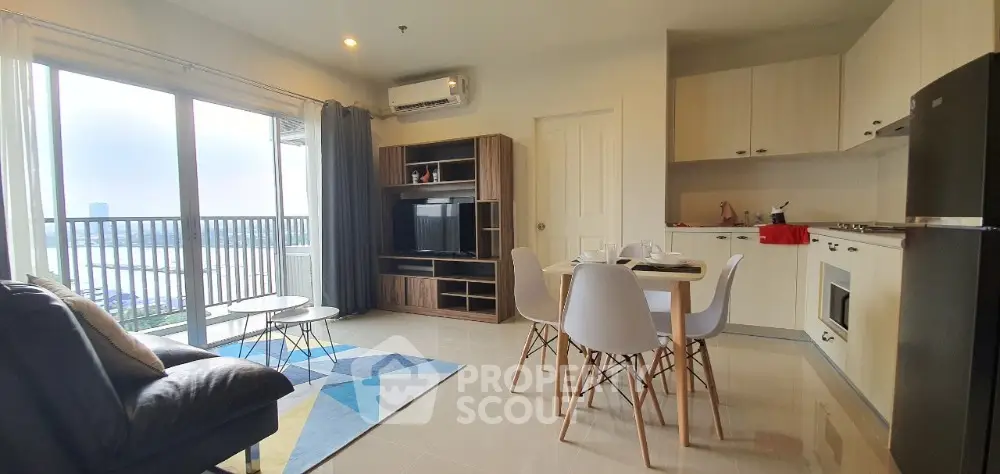 Bright and airy open-plan living space with modern kitchen, cozy dining area, and comfortable lounge leading to a sunny balcony with a view.