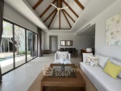 Luxurious living room with high ceiling and pool view, featuring elegant decor and spacious layout.