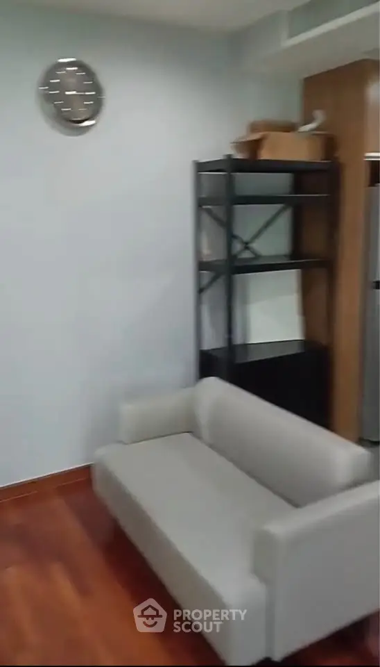Modern living room with sleek sofa and wooden flooring, ideal for cozy urban living.