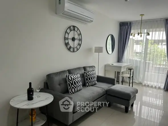 Modern living room with stylish decor and natural light, featuring a comfortable gray sofa and elegant furnishings.