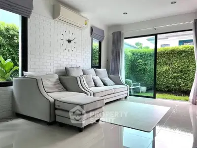 Stylish living room with modern furniture and garden view, perfect for relaxation.