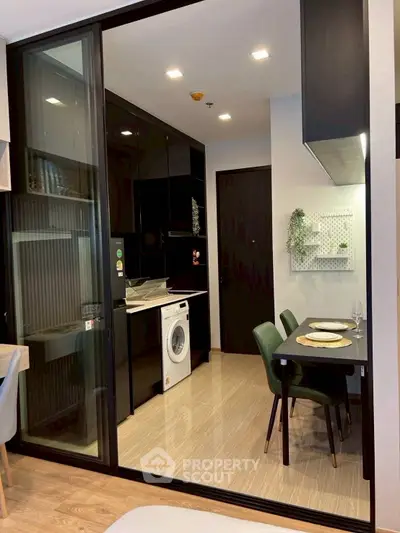 Modern kitchen with sleek black cabinets and dining area in stylish apartment
