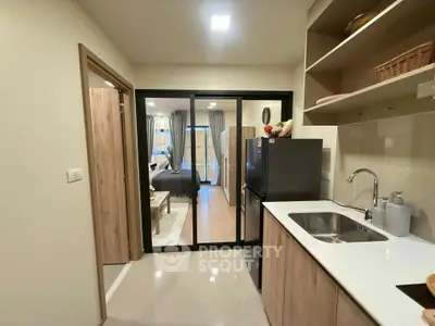 Modern open-layout kitchen with sleek cabinetry and view into cozy bedroom