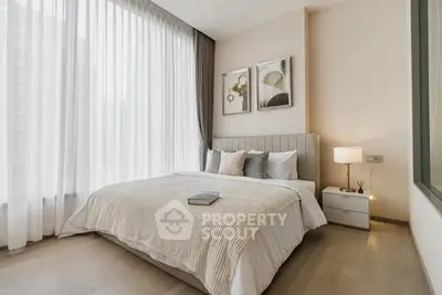 Elegant bedroom with large windows and modern decor in a luxury apartment.