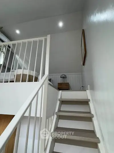 Modern loft bedroom with stylish staircase and cozy decor