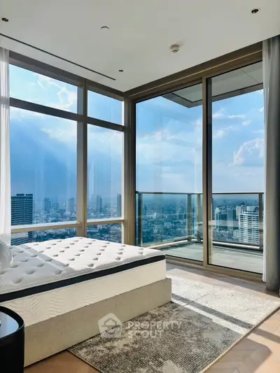 Luxurious bedroom with floor-to-ceiling windows offering stunning city views and abundant natural light.