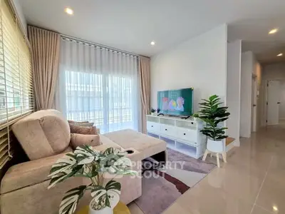 Modern living room with cozy sofa, stylish decor, and large windows for natural light.