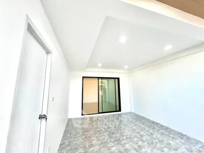 Spacious modern room with sleek tiled flooring and large window for natural light.