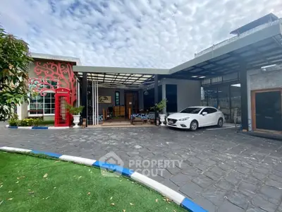 Charming modern house with carport and unique red phone booth feature.