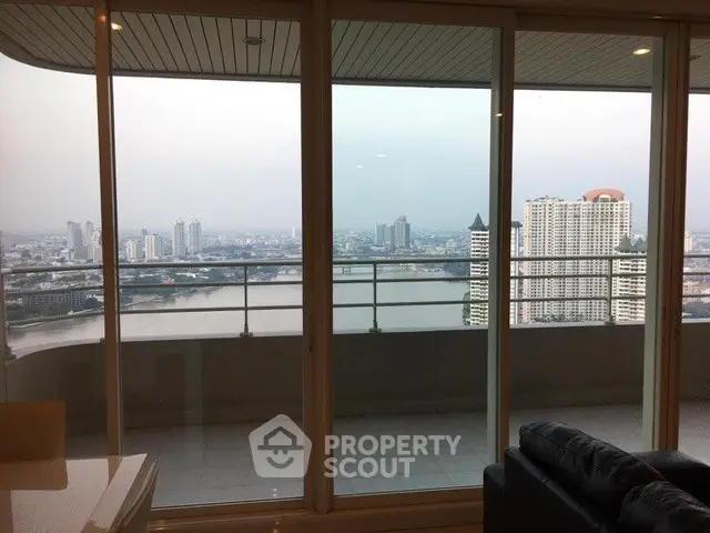 Stunning high-rise apartment with panoramic city and river views from a spacious balcony.