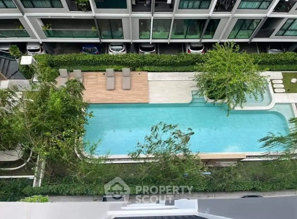 Modern apartment complex with a stylish outdoor pool and lush greenery, offering a serene urban oasis.