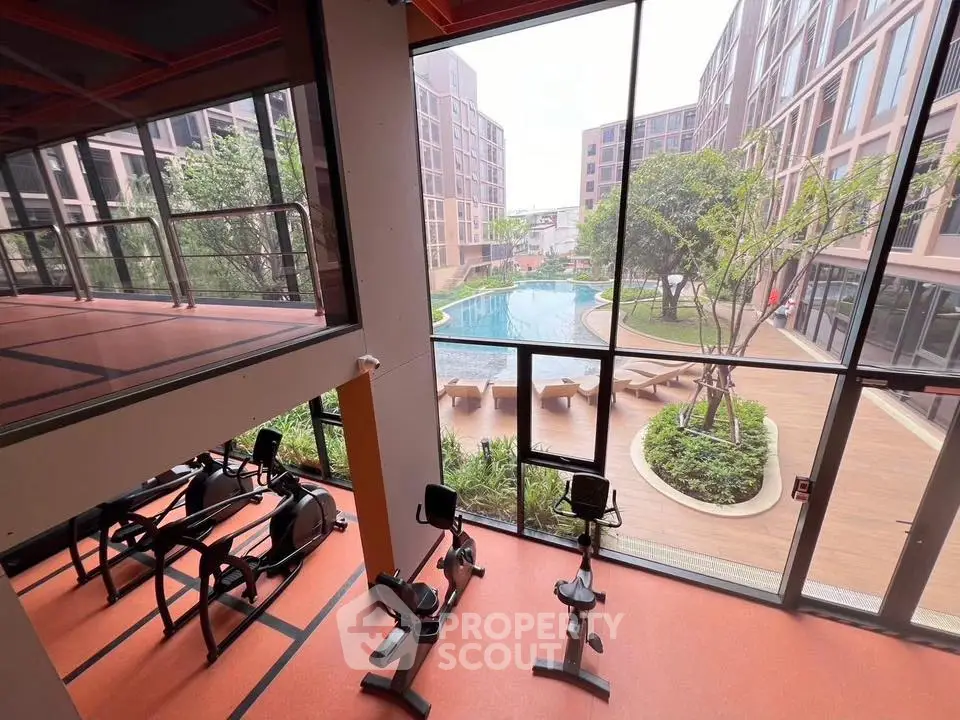 Modern gym with pool view in luxury apartment complex