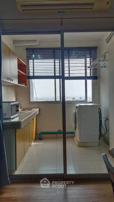 Spacious laundry room with washing machine and ample storage in modern apartment.