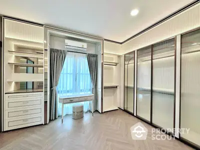 Luxurious walk-in closet with elegant cabinetry and natural light