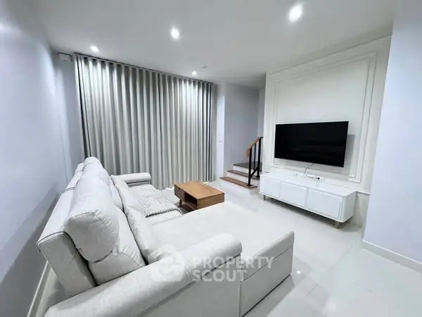 Modern living room with sleek furniture and wall-mounted TV
