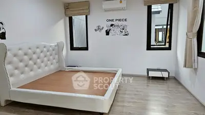 Spacious bedroom with modern decor and ample natural light, featuring a unique One Piece wall art.