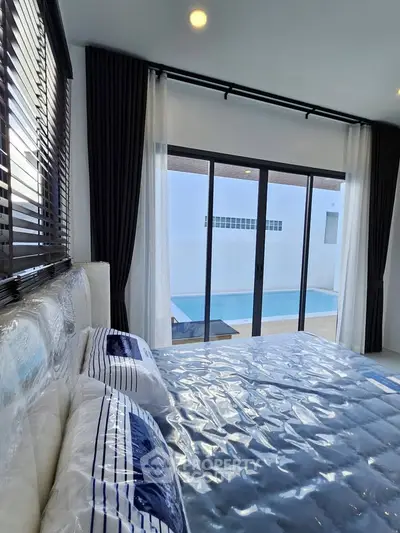 Luxurious bedroom with pool view and modern decor in a stylish home