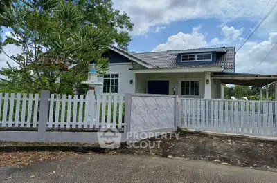 Charming single-story house with white picket fence and lush greenery