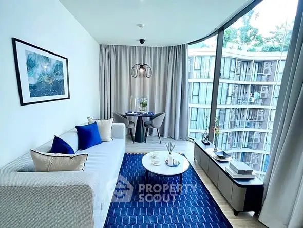 Modern living room with large windows and stylish decor in a high-rise apartment.