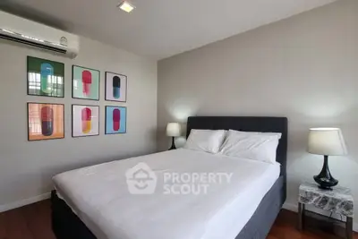 Modern bedroom with stylish decor and cozy lighting, featuring a comfortable bed and contemporary artwork.