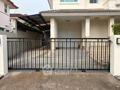 Spacious residential property with secure gated entrance and covered parking area.