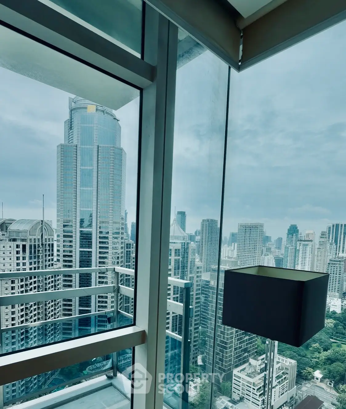 Stunning cityscape view from modern high-rise apartment with floor-to-ceiling windows.