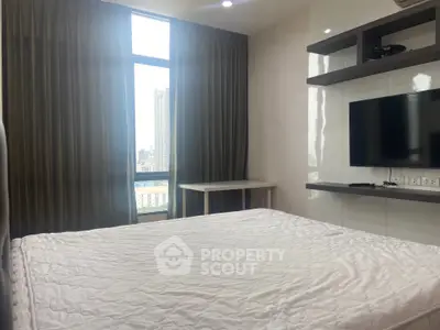 Modern bedroom with large window and wall-mounted TV in urban apartment