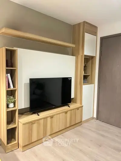 Modern living room with sleek wooden TV stand and shelving, perfect for stylish urban living.