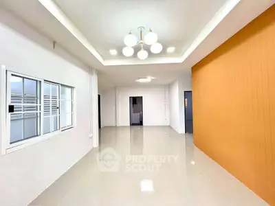 Spacious modern living room with elegant lighting and vibrant accent wall