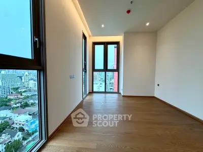 Spacious modern room with large windows offering stunning city views, perfect for urban living.