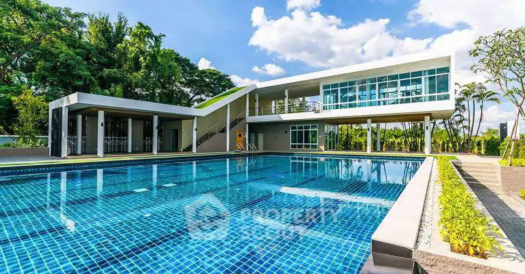 Modern building with a luxurious outdoor pool and lush greenery, perfect for relaxation and leisure.
