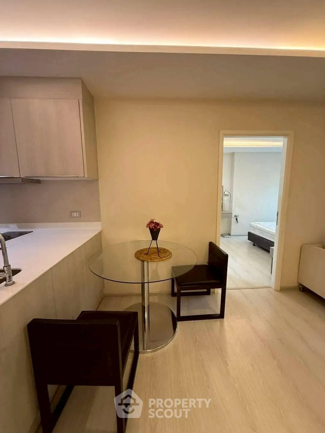 Modern apartment interior with cozy dining area and view into bedroom
