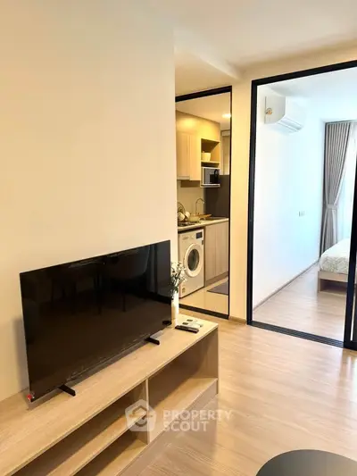 Modern apartment interior with open layout, featuring a cozy living area and compact kitchen.