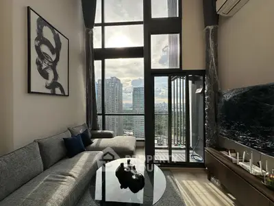 Luxurious high-rise living room with floor-to-ceiling windows and stunning city view.