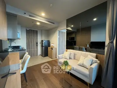 Modern living room with sleek kitchen and cozy seating area in a stylish apartment.