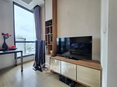 Modern living room with TV, large window, and stylish furniture in a high-rise apartment.