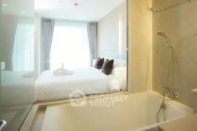 Luxurious bedroom with ensuite bathroom featuring a modern bathtub and elegant decor.
