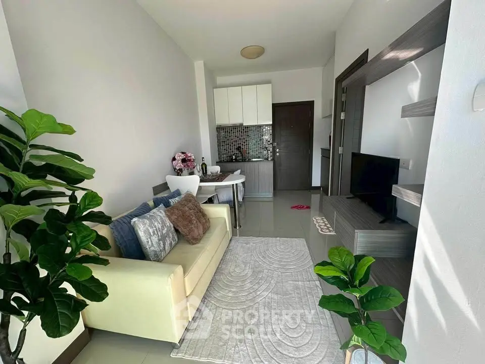 Modern living room with cozy sofa, stylish decor, and open kitchen layout in a bright apartment.