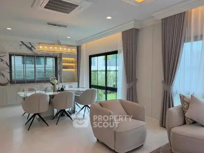 Elegant living and dining area with modern furniture and large windows for natural light.