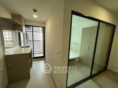 Modern apartment with sleek kitchen and sliding glass doors to bedroom